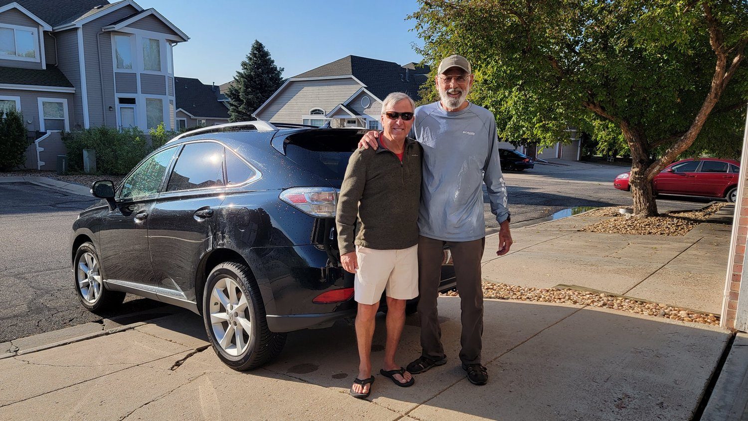 Kevin and an older man standing together by a car before an outing
