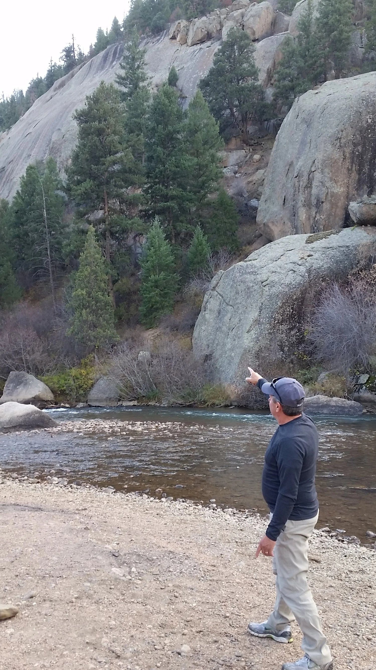 Looking out over a calm river below granite cliffs